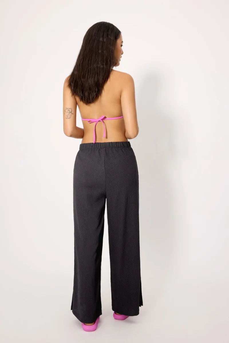Conjunto de praia com um top preto com nós e calças pretas claras - Image 5
